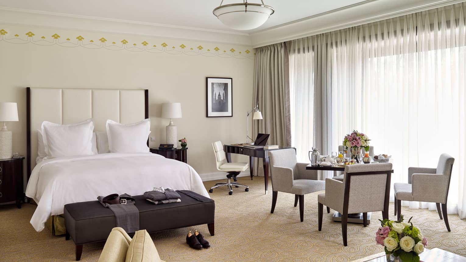 Park Suite dining table with in-room dining breakfast in front of long white curtains, beside bed and desk
