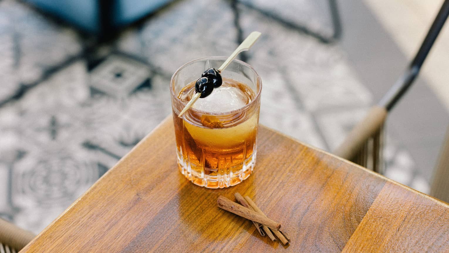 A cocktail with blueberries as a garnish.