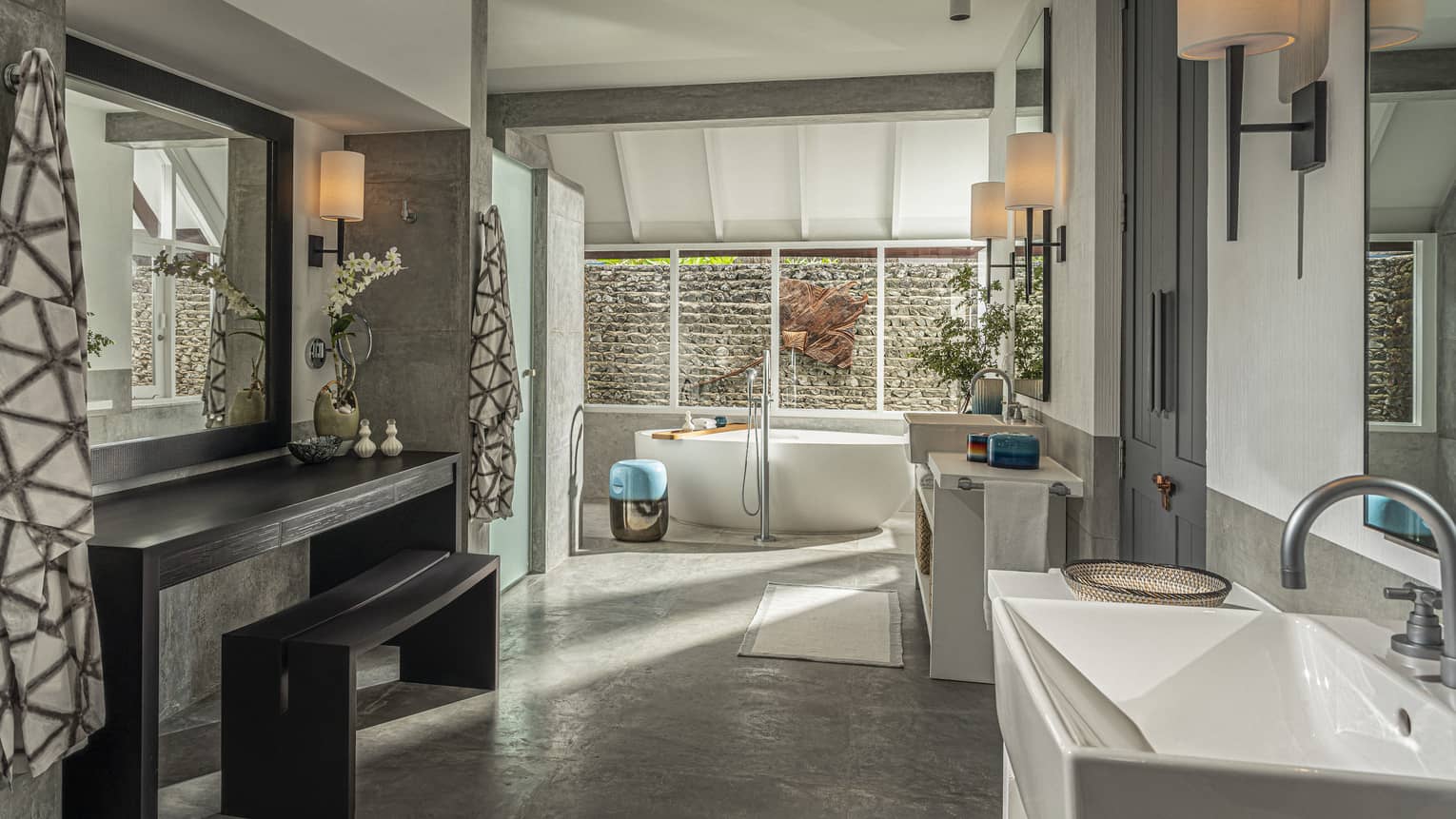 Large master bathroom with freestanding tub by window and wooden vanity