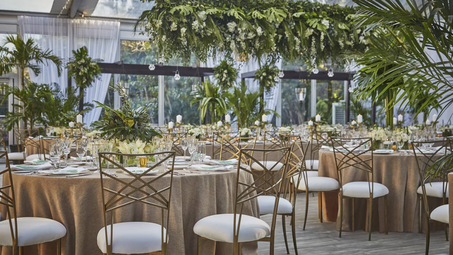 Wedding banquet, round dining tables with tropical greenery