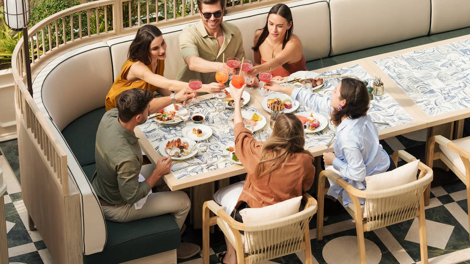 Group of six people dining together at an outdoor restaurant table