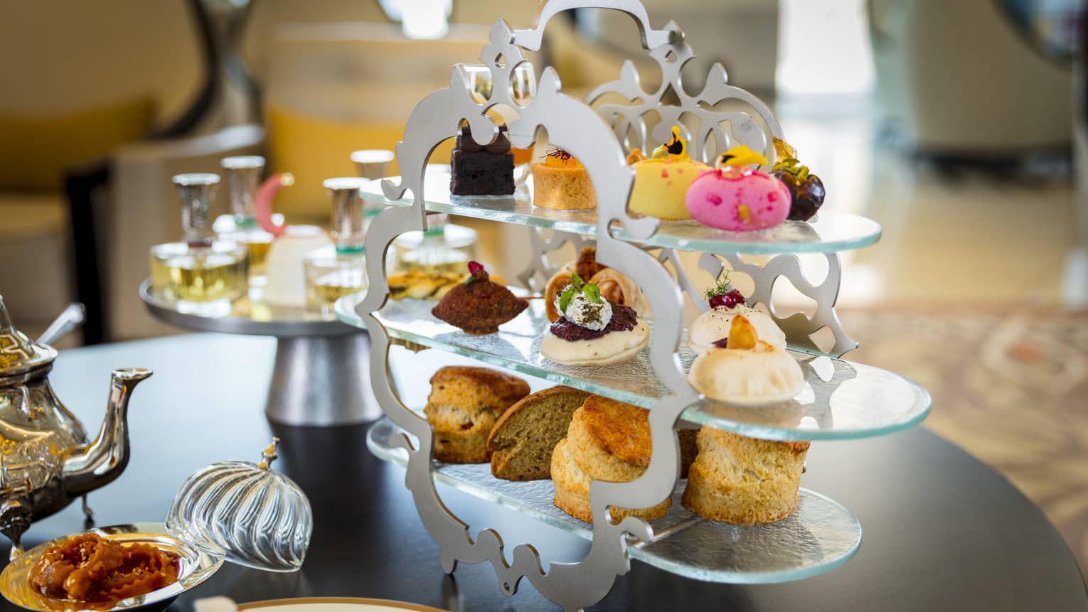 Arabian banquet three-tiered dessert tray with small cakes on tea service table