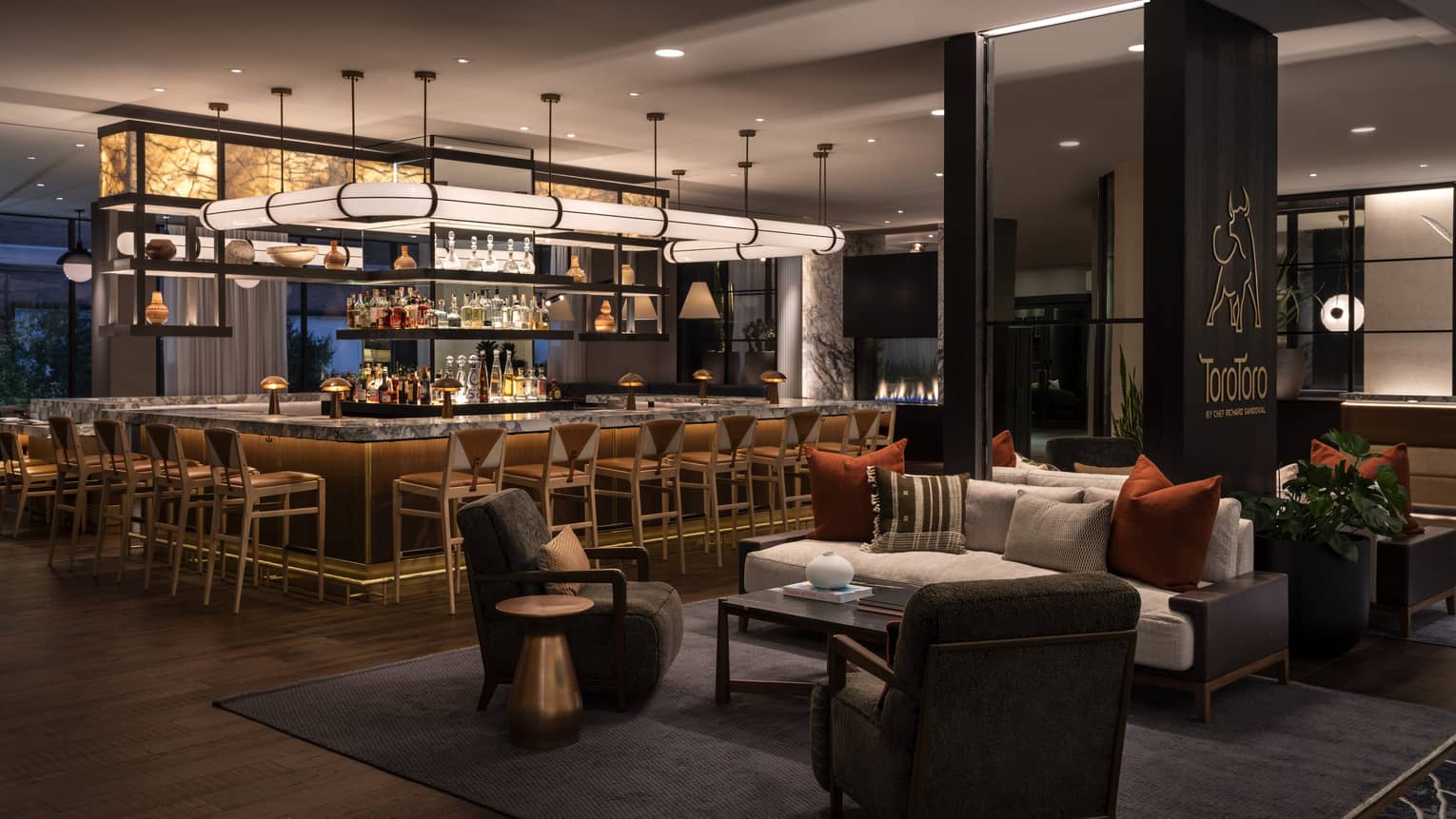 The interior of a dimly lit restaurant with a large bar area in the center.