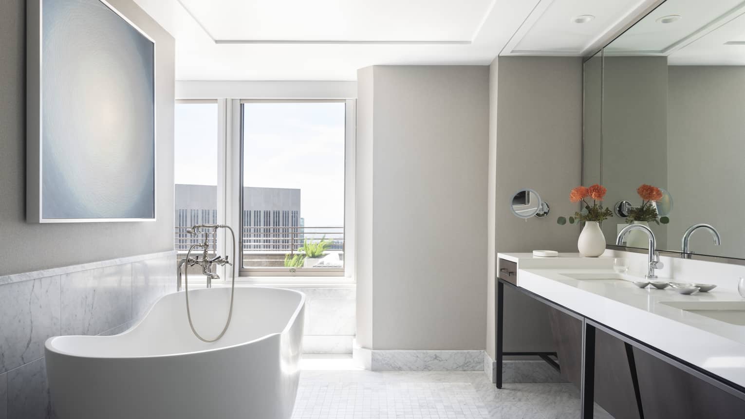 Bathroom with free-standing tub, double vanity and window