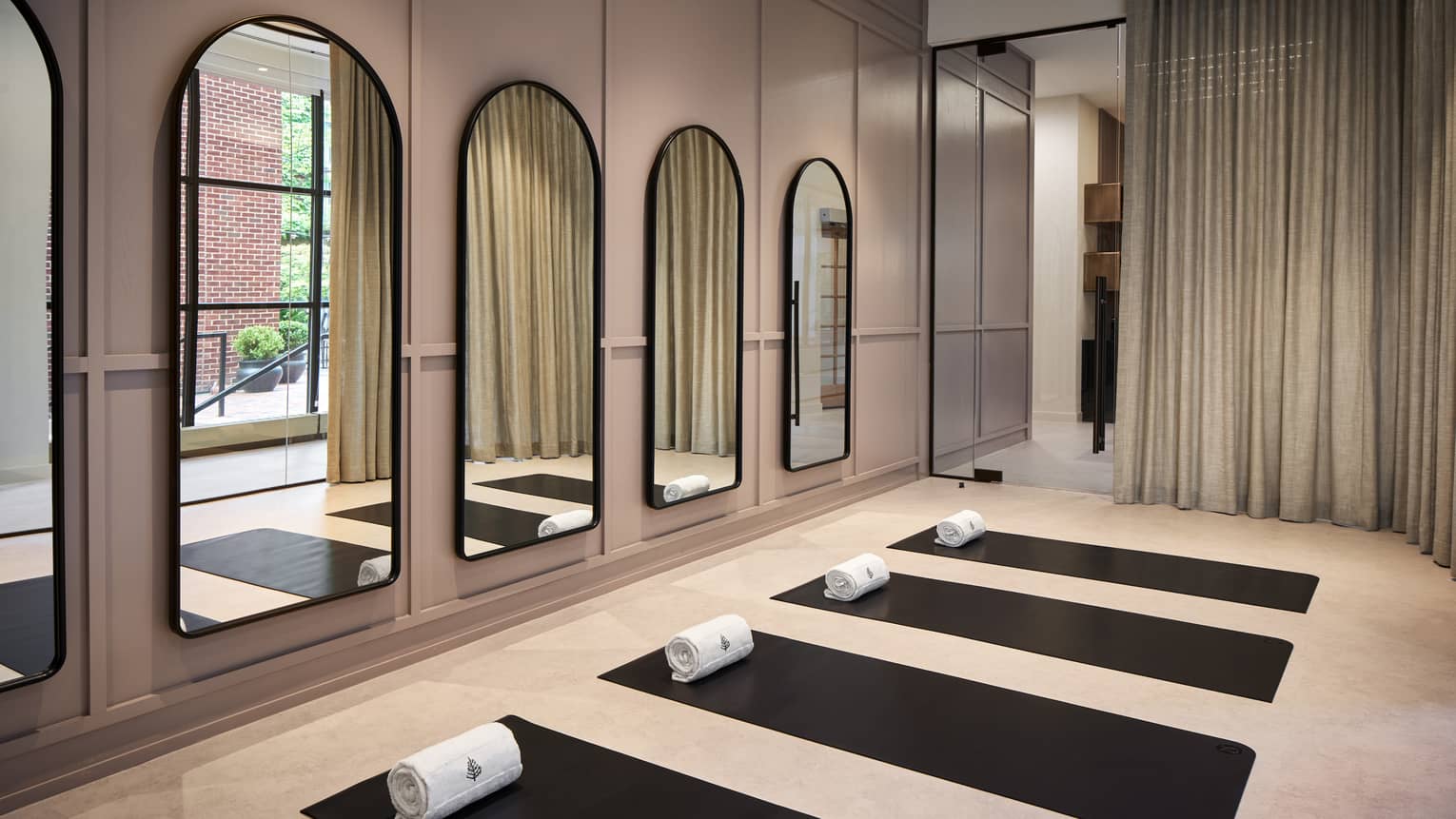 Yoga mats in a yoga studio with mirrors on the wall.