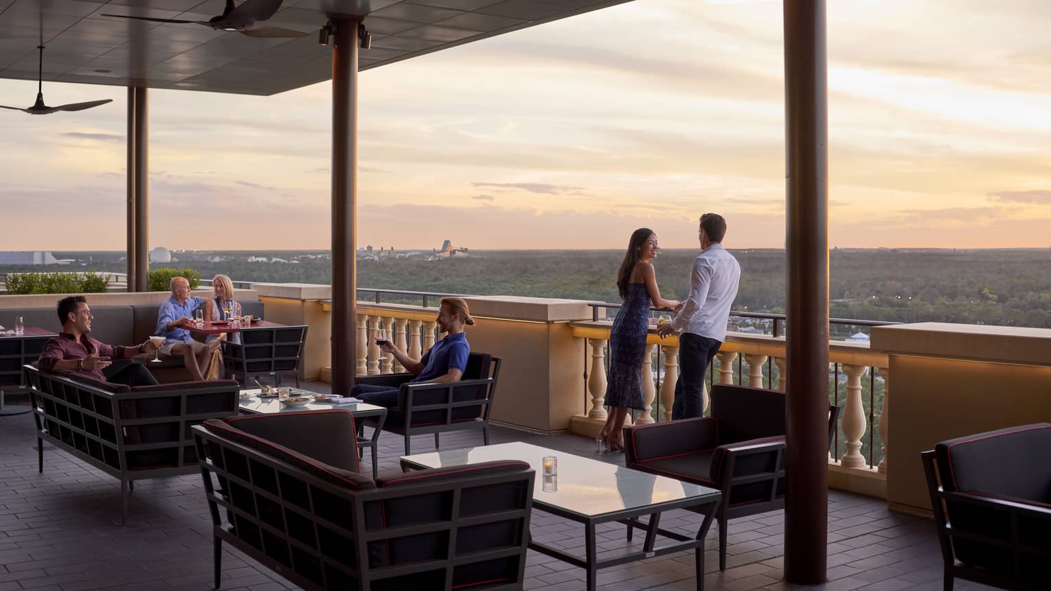 People lounge on Capa Bar terrace under roof at sunset