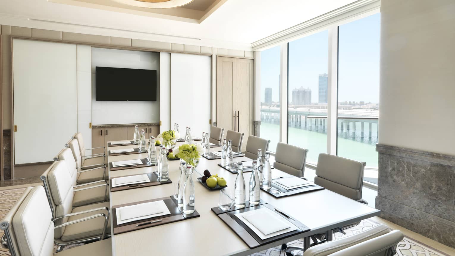 White leather chairs around small table in sunny Al Ain meeting room with Gulf, city view