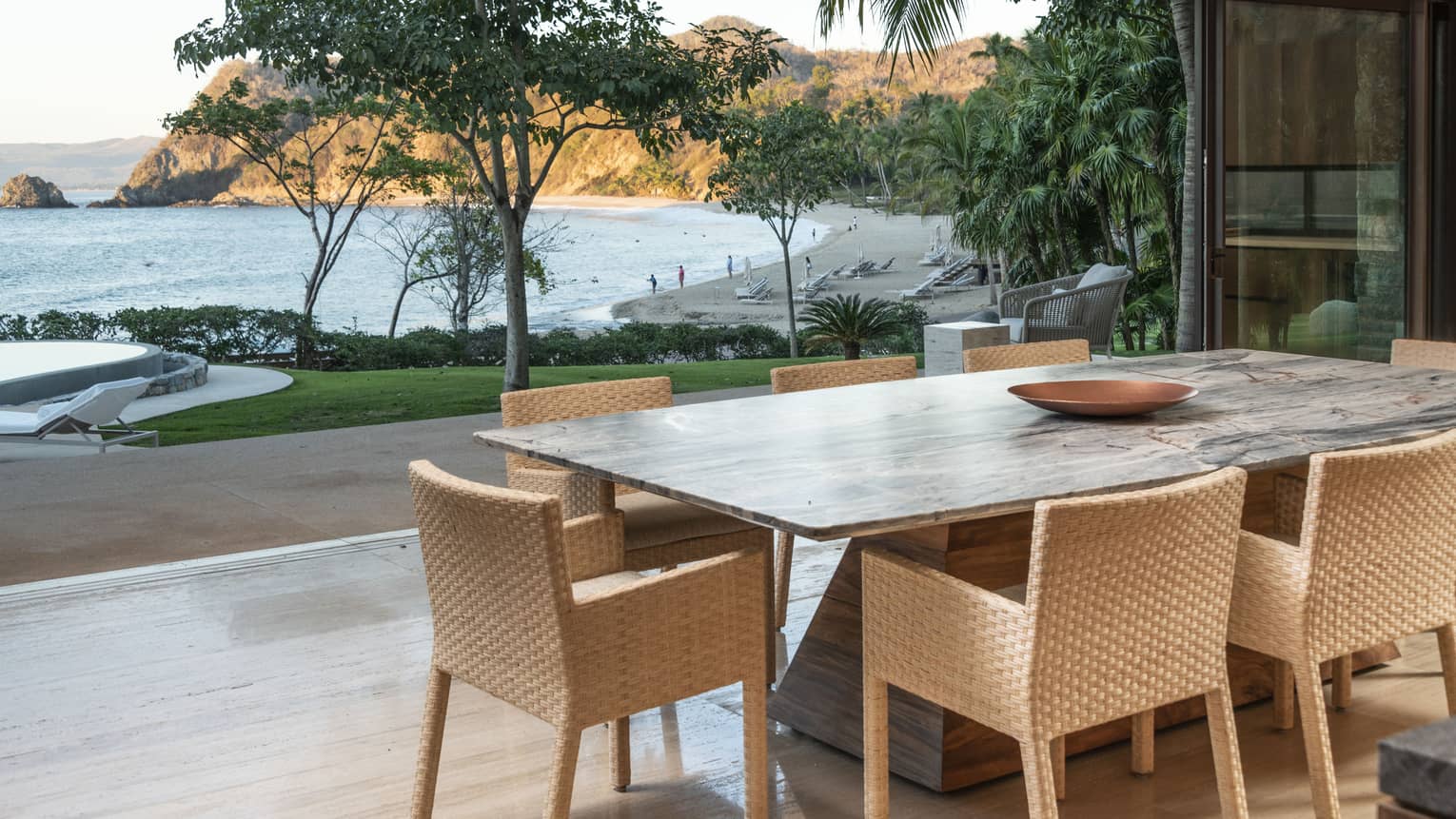 Dining table and open-air terrace with view of ocean and beach