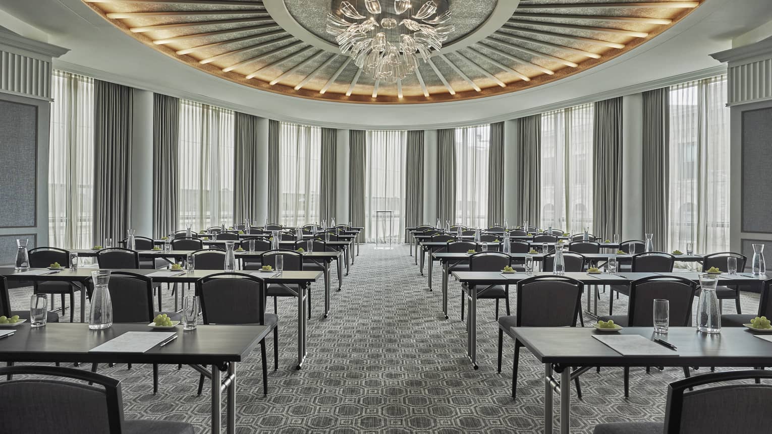 Beacon room, empty, but ready for a meeting and event, with the rectangular tables set with a water glass and notebook and pen