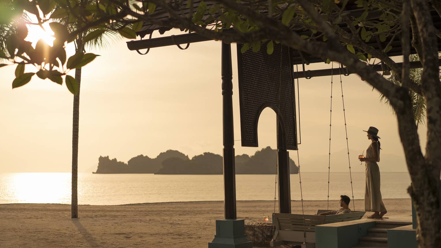 A woman overlooks the water on the beach at Rhu Bar