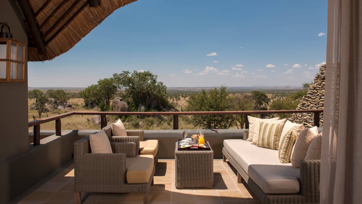 Horizon Room Waterhole covered patio with wicker chairs, sofa, breakfast tray