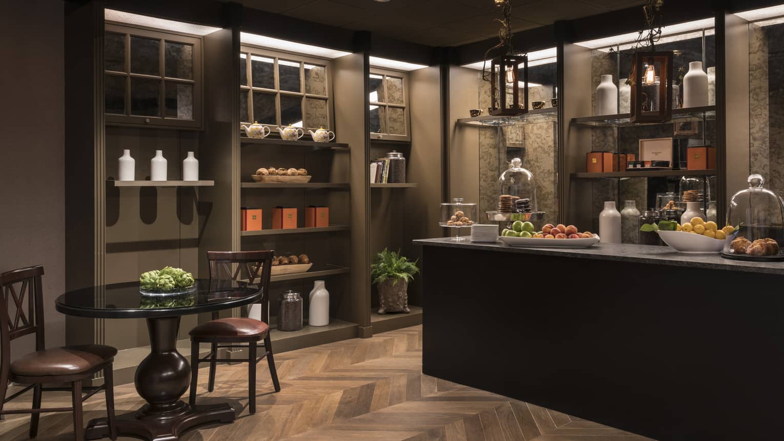 A coffee store that dimly lit with a counter and small table.