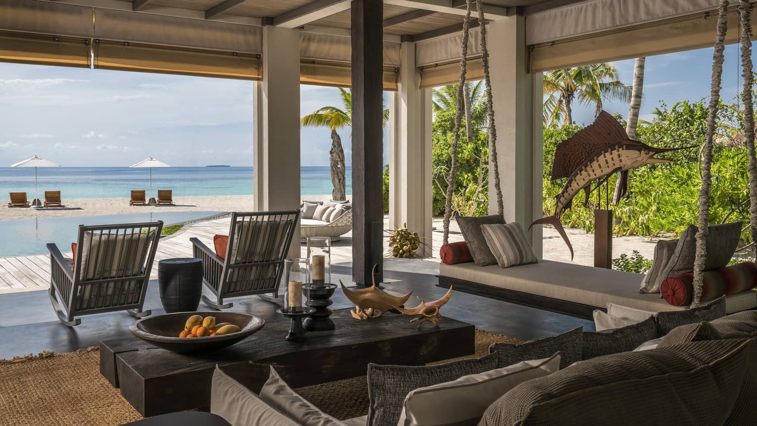 The Beach House open-air living room, sofa, table with oranges and wood manta ray carvings