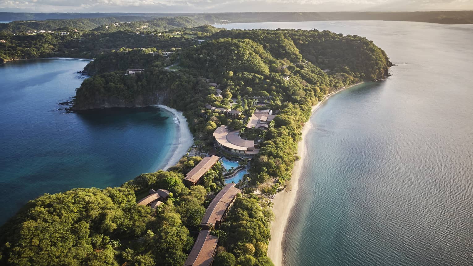 Aerial view of Papagayo Peninsula, a thin strip of land covered in trees with blue ocean water on either side