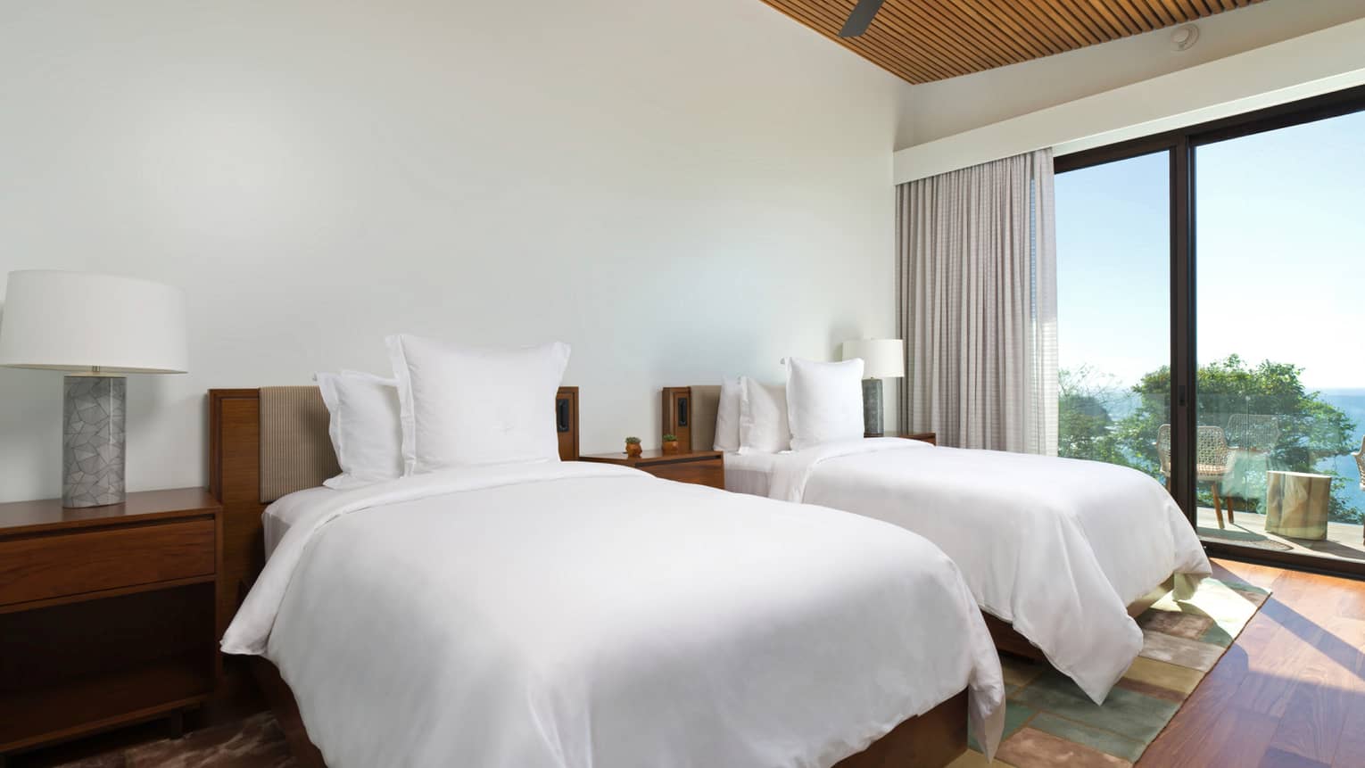 Bedroom with two beds and ocean-view balcony