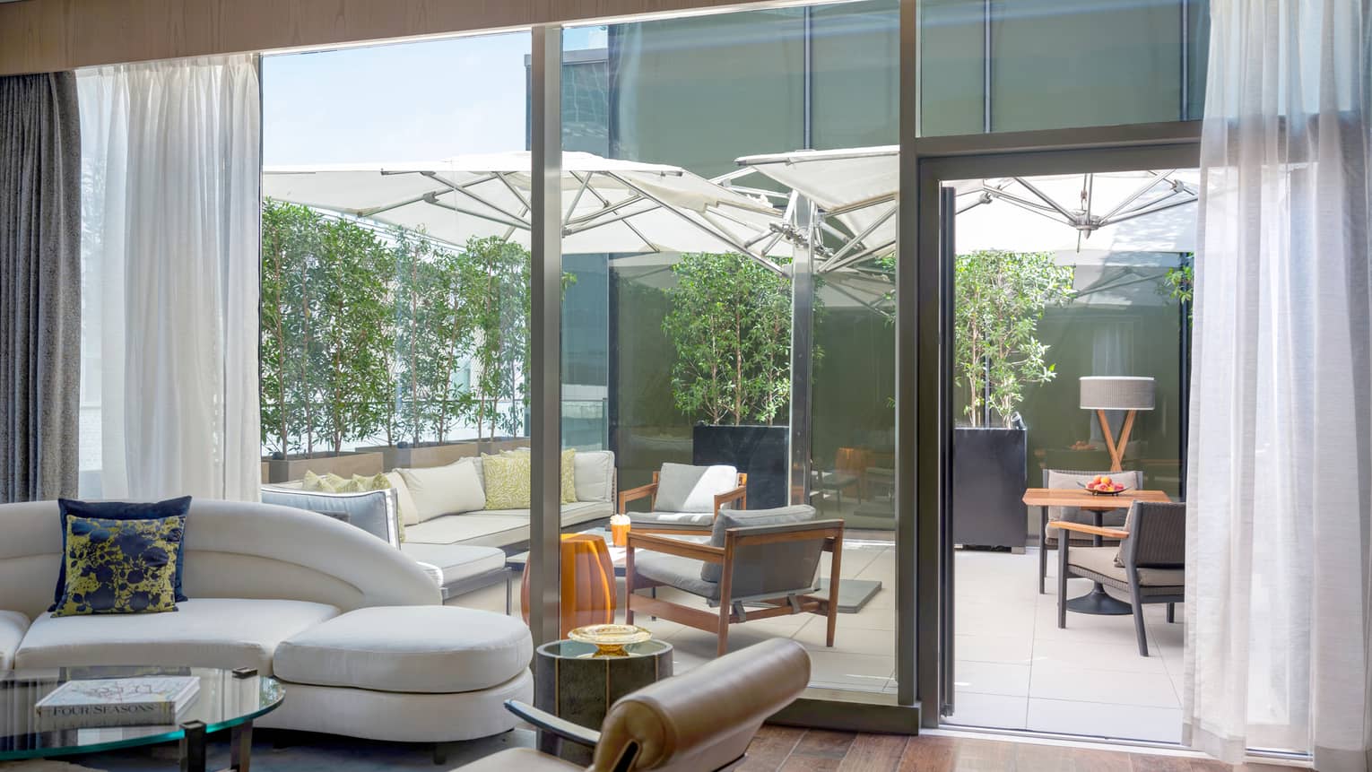 Living room with wooden floors, walk-out terrace with lounge furniture