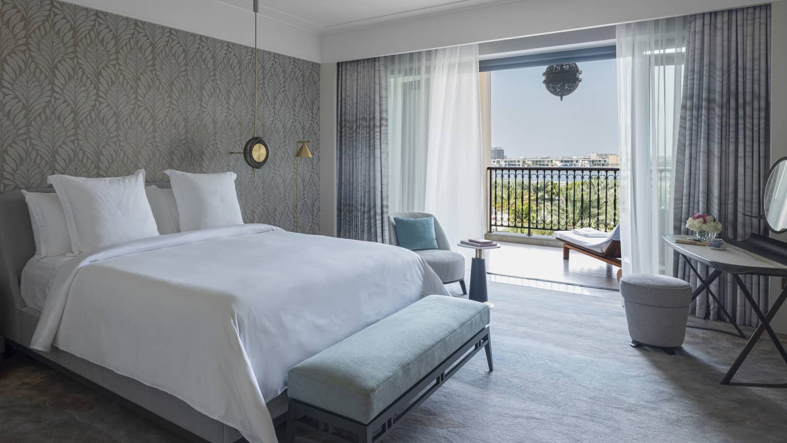Hotel room with king bed, bench, make-up vanity and walk-out balcony