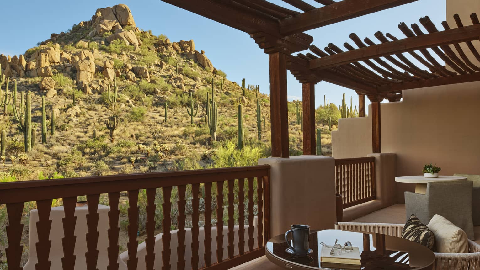 Private terrace with two sets of table and two chairs, with desert mountain view