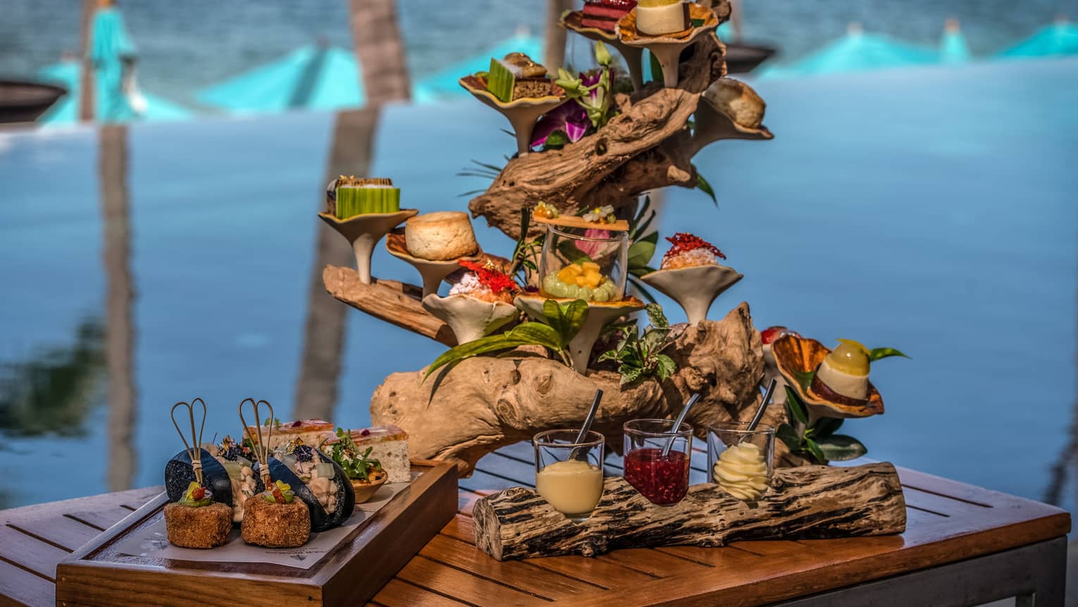 Afternoon tea spread with sweets and savouries presented on a piece of driftwood