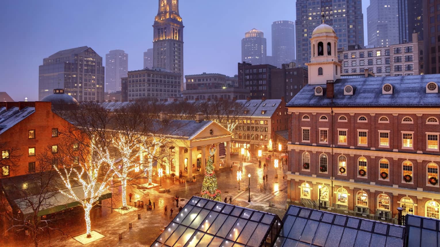 Boston historic buildings and courtyard in winter at night, with trees wrapped in Christmas lights