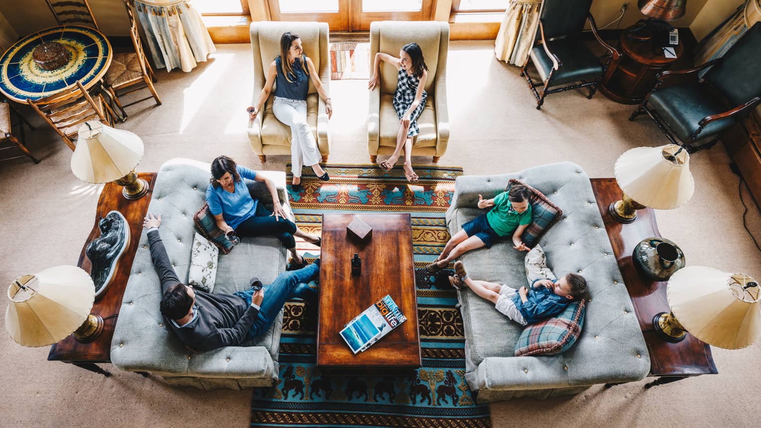 Aerial view of guests talking and relaxing in the living room of a residence 