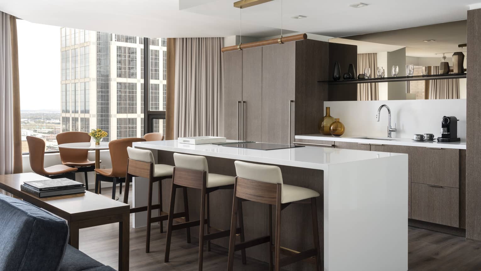 A kitchen area with large island near large windows in a hotel suite.