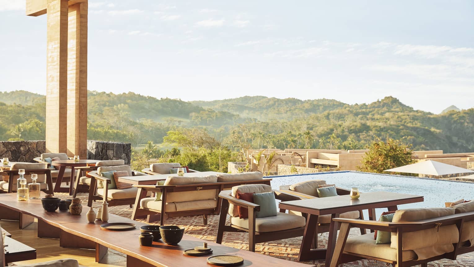 An outdoor terrace of a restaurant looking out at a forest.