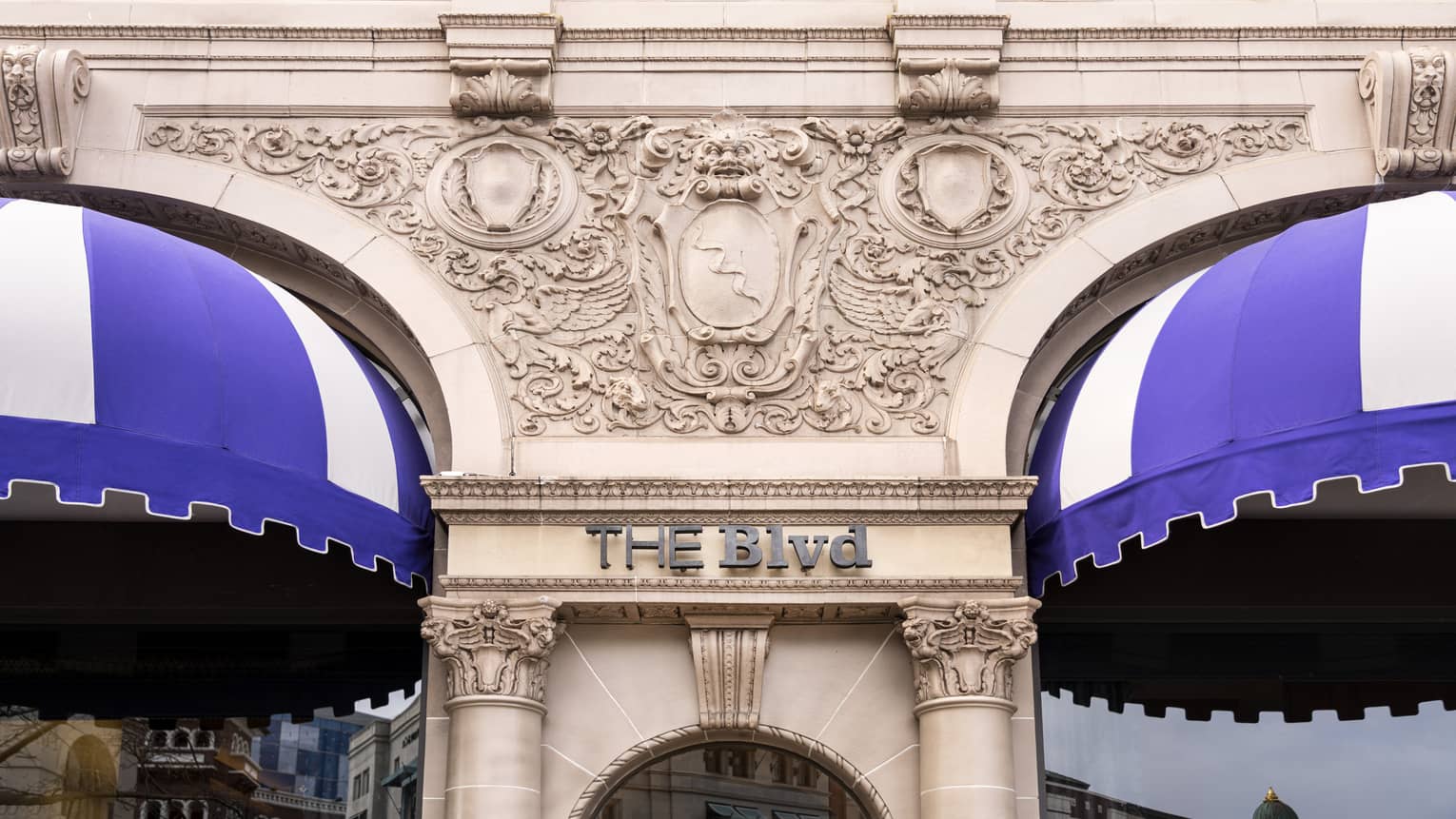 A restaurant sign that says "THE Blvd" on a stone building.