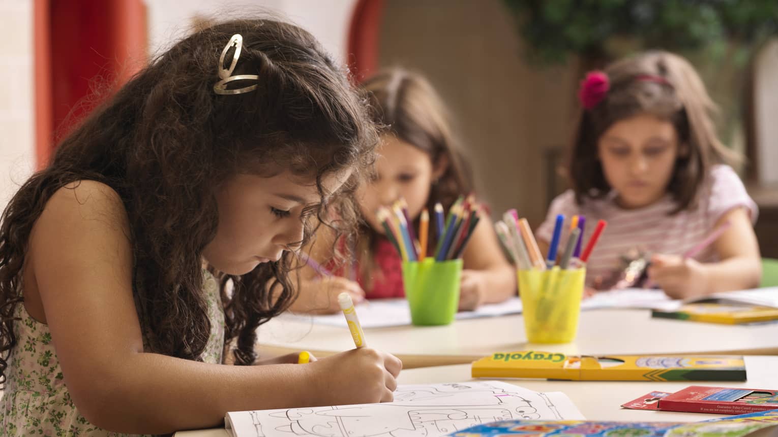 A group of young girls using markers on colouring books.