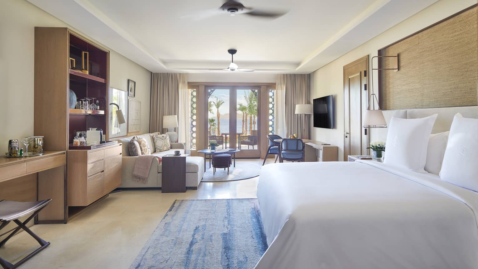 Bedroom with king bed, sitting area and glass doors to patio