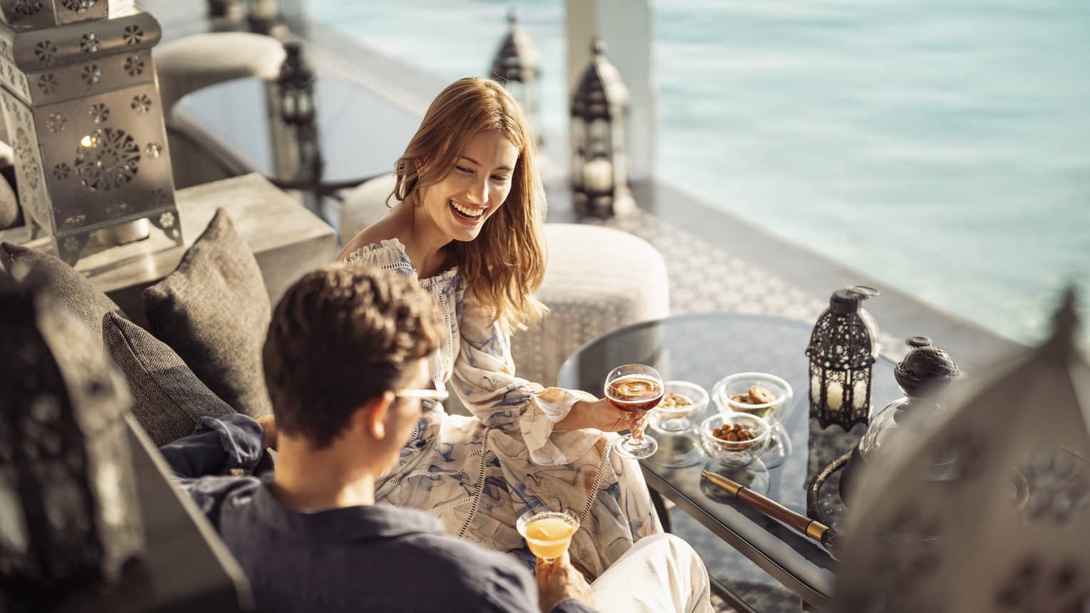 Smiling couple enjoys mezze poolside at Al Barakat