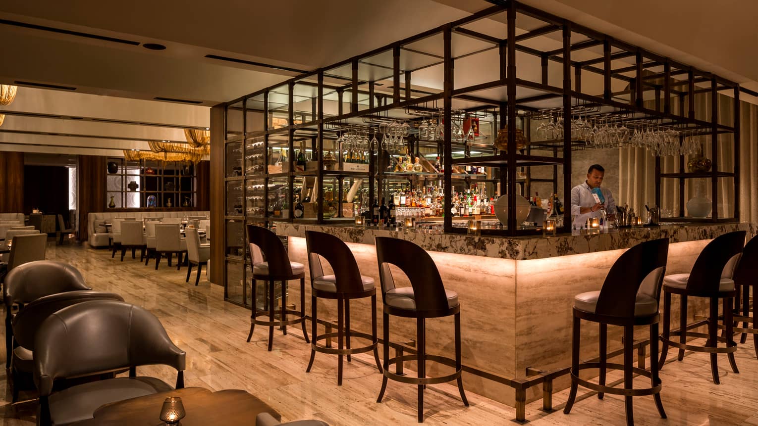 Modern framed bar with bartender, brown curved-back barstools and chairs, round tables, wood floor