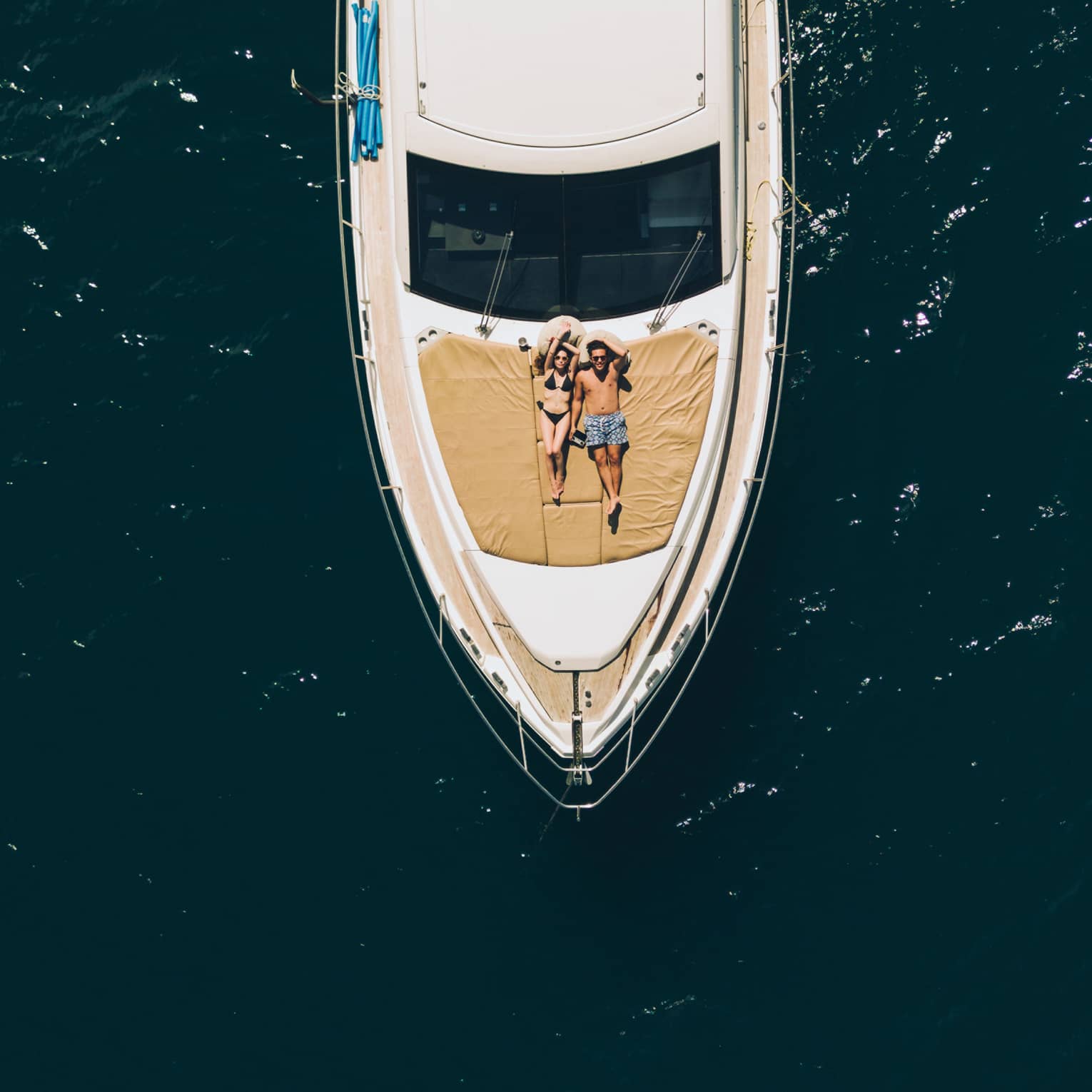 Aerial view of couple relaxing on the front of a large boat