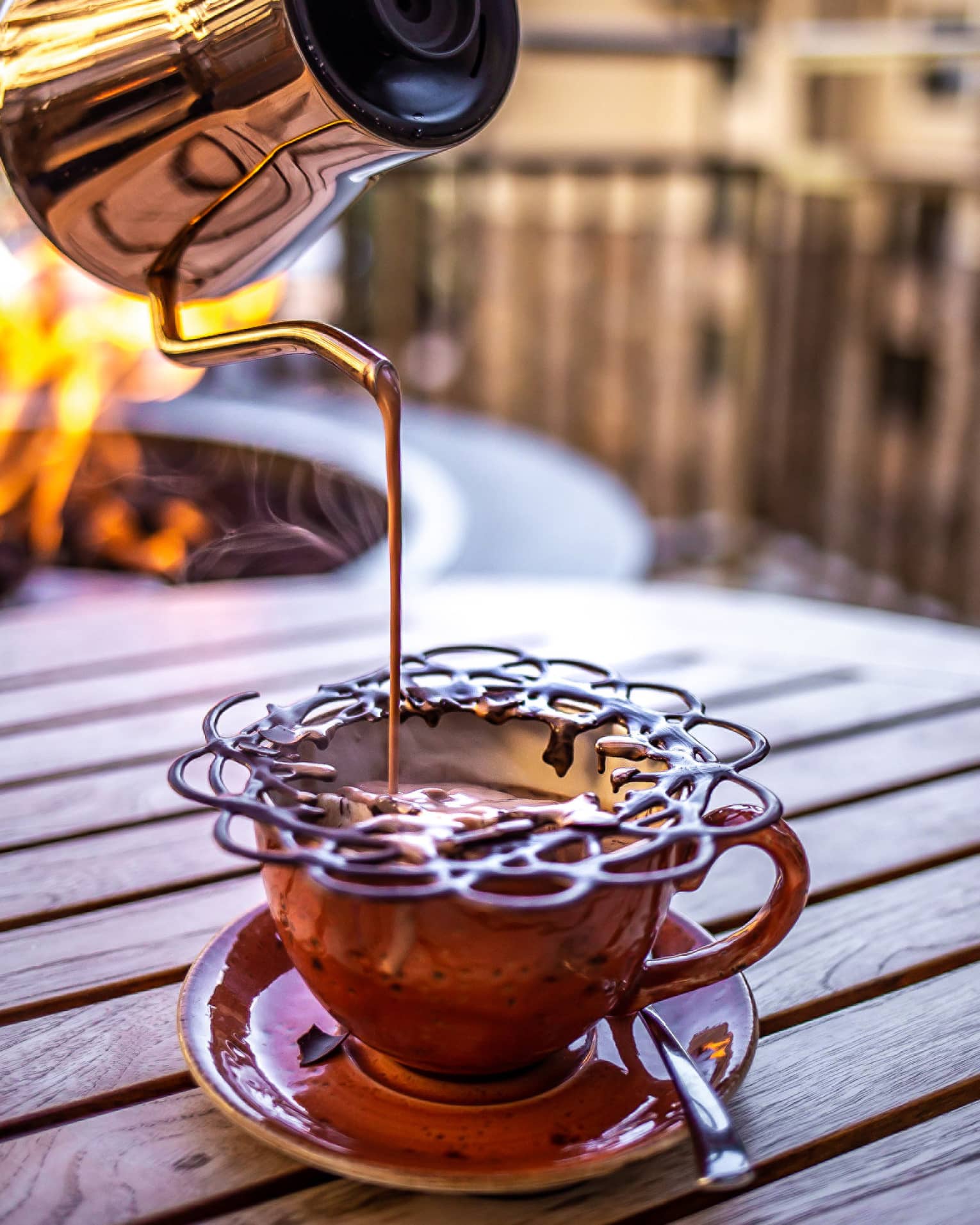 Hot chocolate being poured into a metal cup.