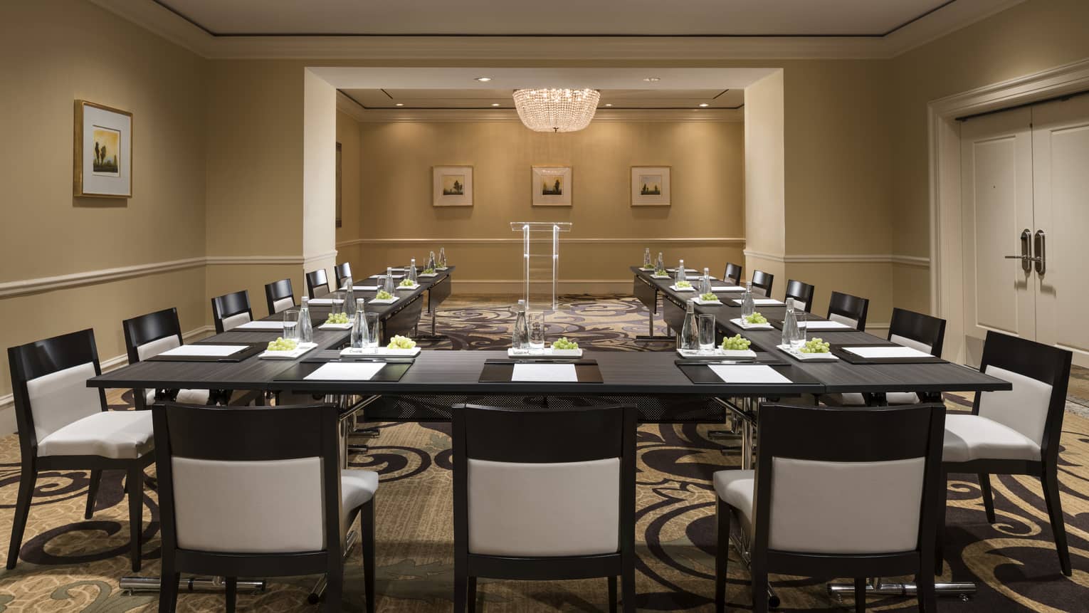 Meeting room with modular boardroom tables lines with white chairs 