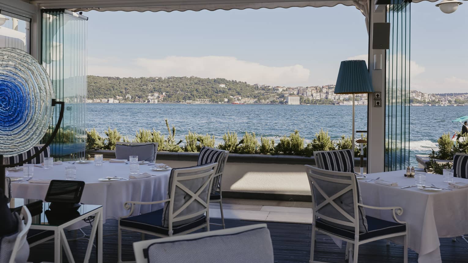Waterfront restaurant covered terrace with casual tables