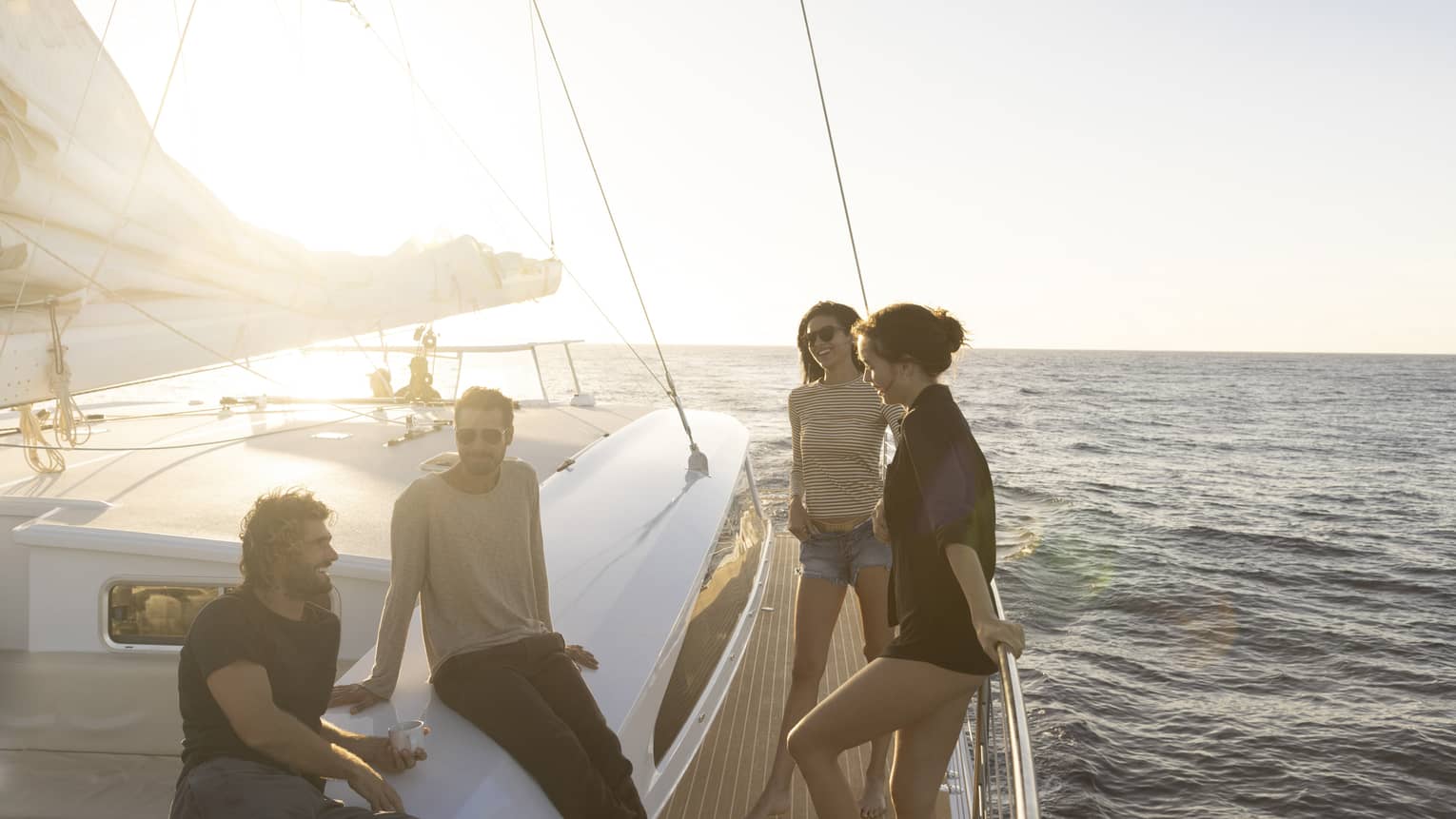 Two women and two men talk on sail boat on the water