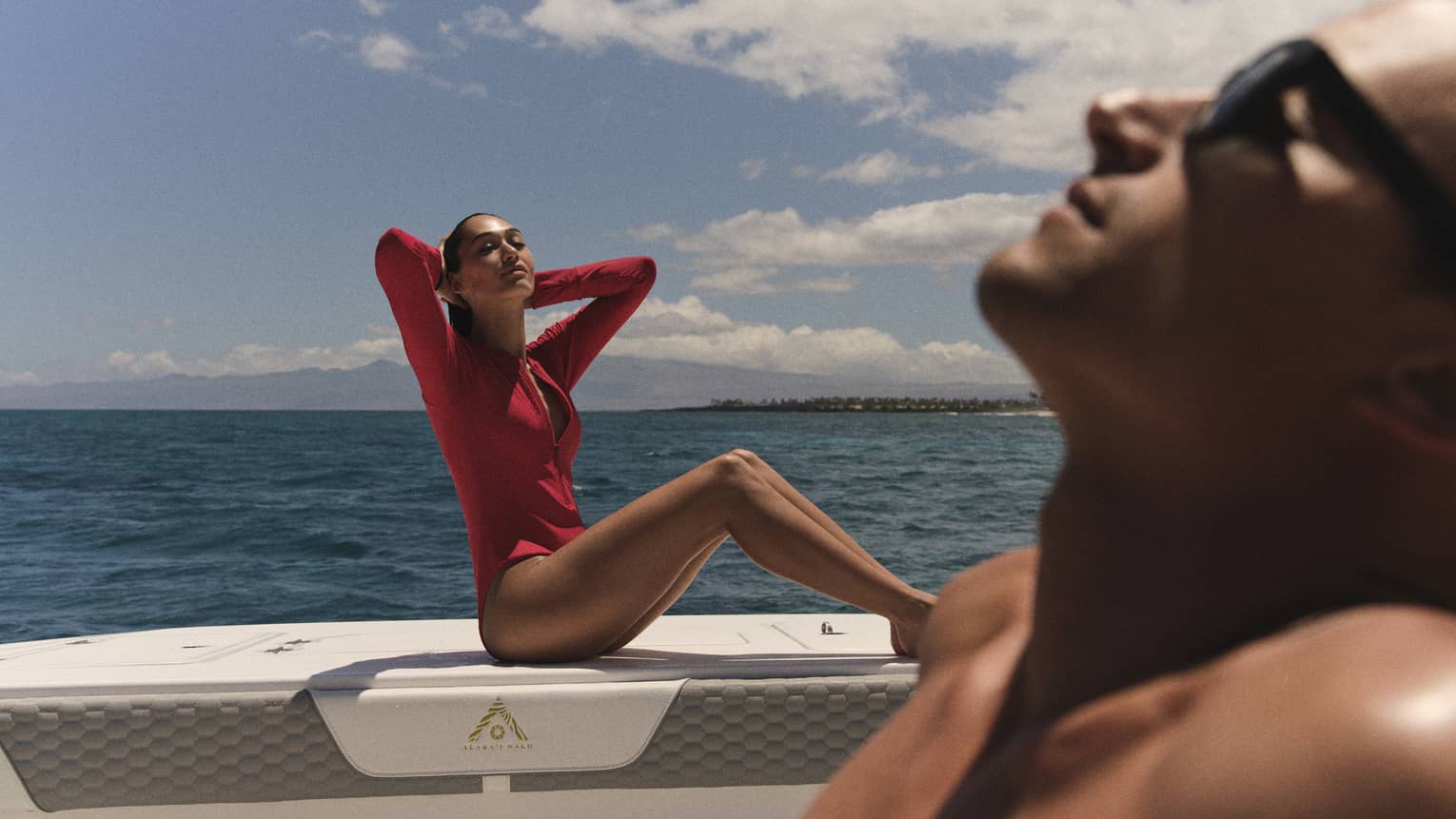 Two people sun tan on a boat at sea