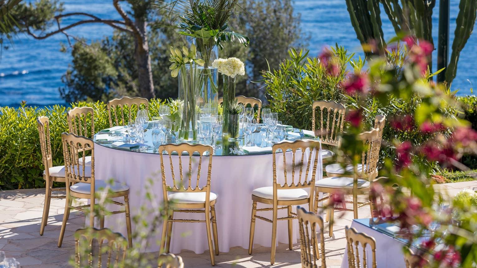 Small round outdoor wedding dining table on patio by sea