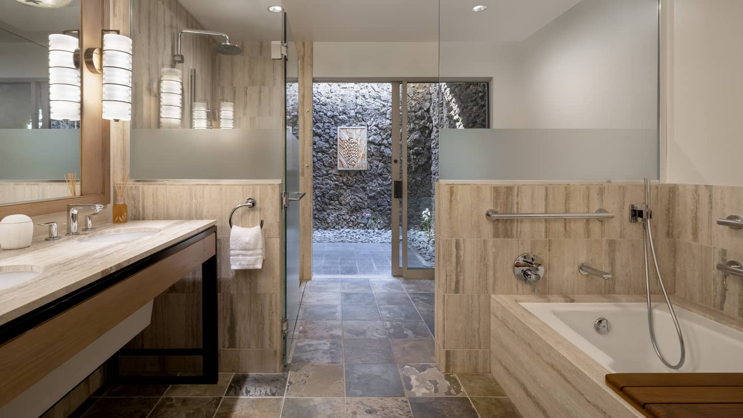 Mobility-accessible bathroom at luxury resort, featuring a roll-in shower and separate tub with grab bars