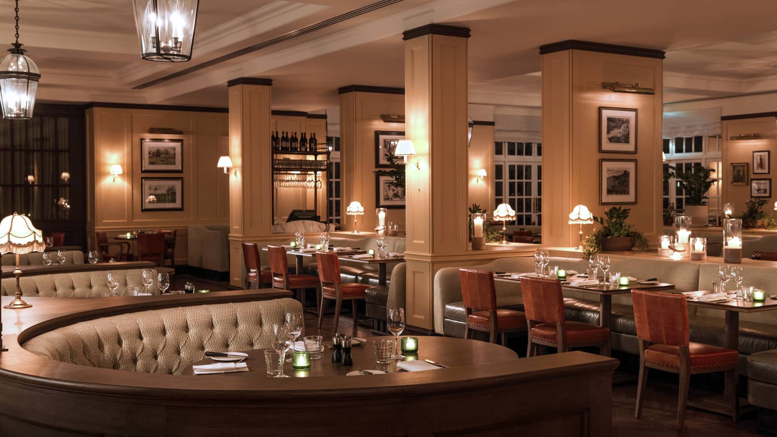 Large curved booths behind tables, chairs in dimly lit dining room