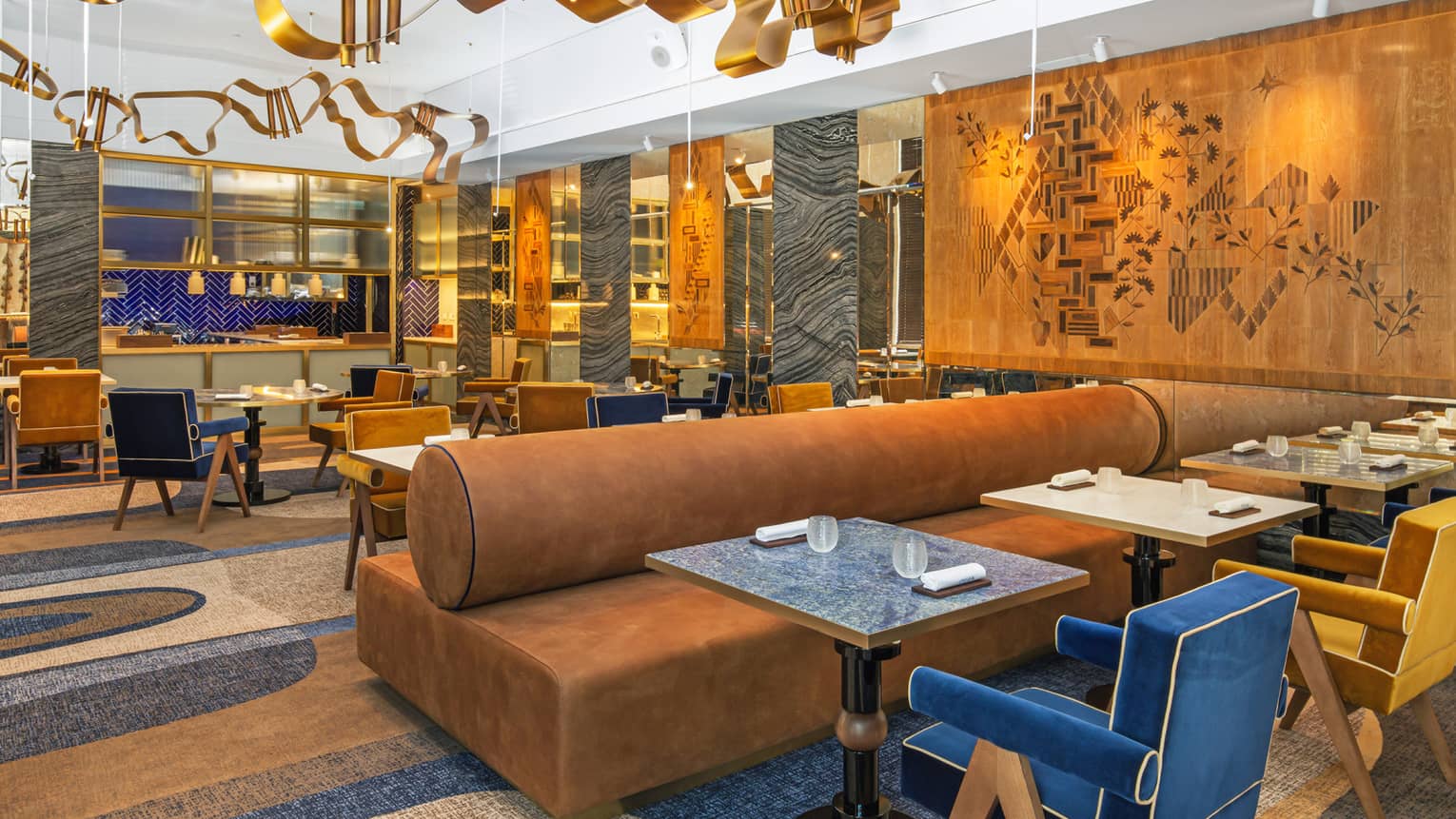 Modern dining area with gold, blue and deep camel accents and art flanking walls and ceiling