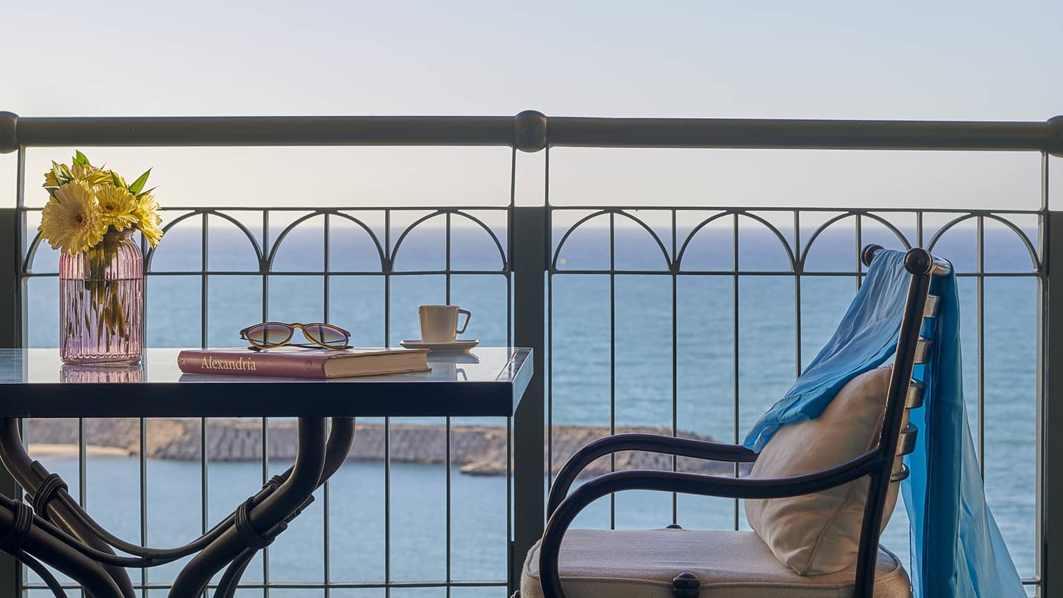 Balcony with small square table and chair, sea views