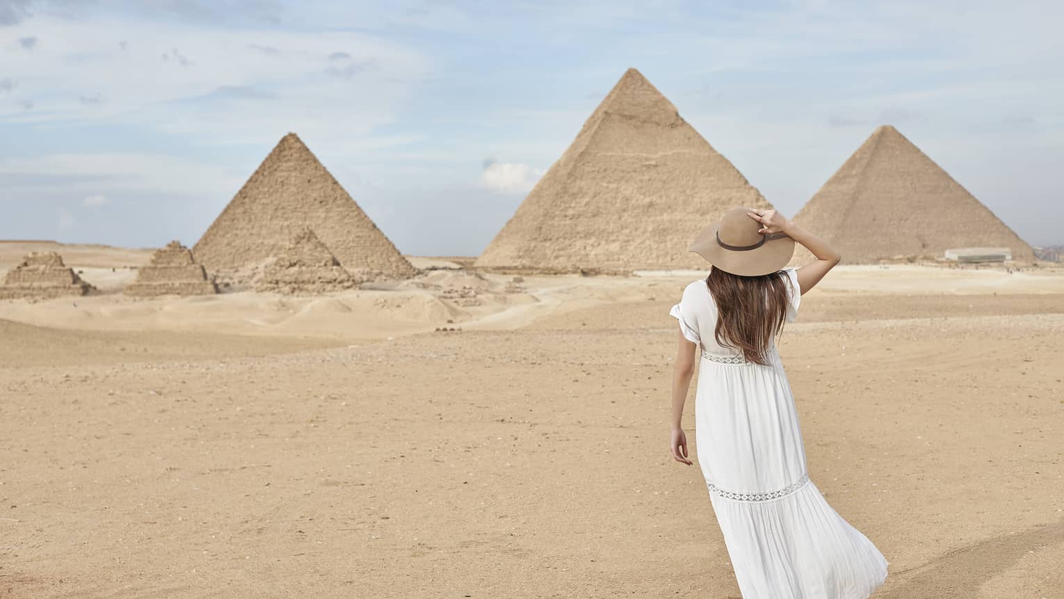 A guest wearing a linen dress observing the Great Pyramids