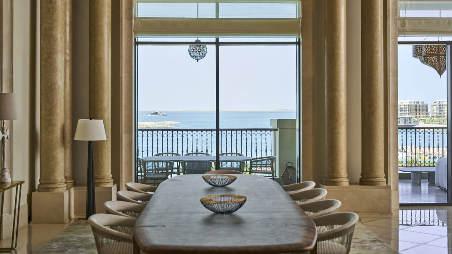 View of the sea through a dining room with a wooden dining table and eight chairs