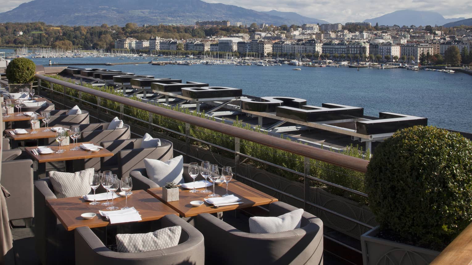 Dining tables along bright Izumi Terrace overlooking water 