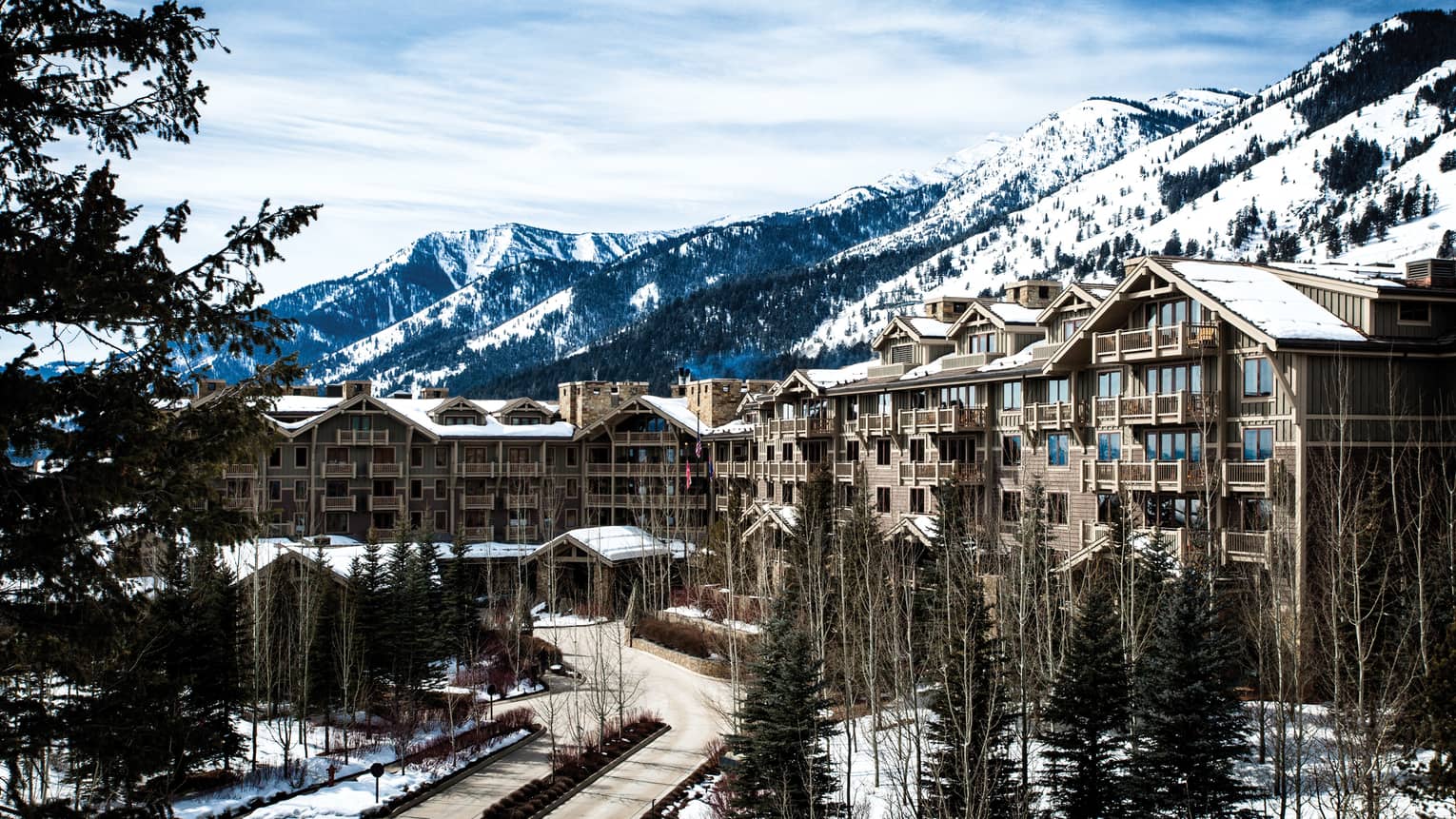 the exterior of the hotel is covered in snow and surrounded by snow capped mountains