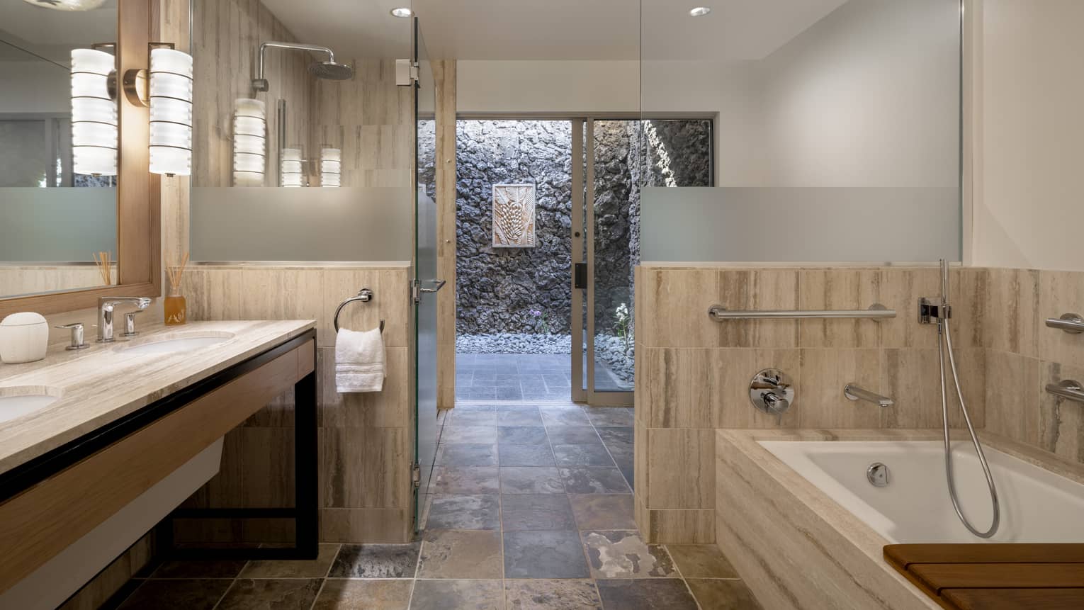 Mobility-accessible bathroom at luxury resort, featuring a roll-in shower and separate tub with grab bars