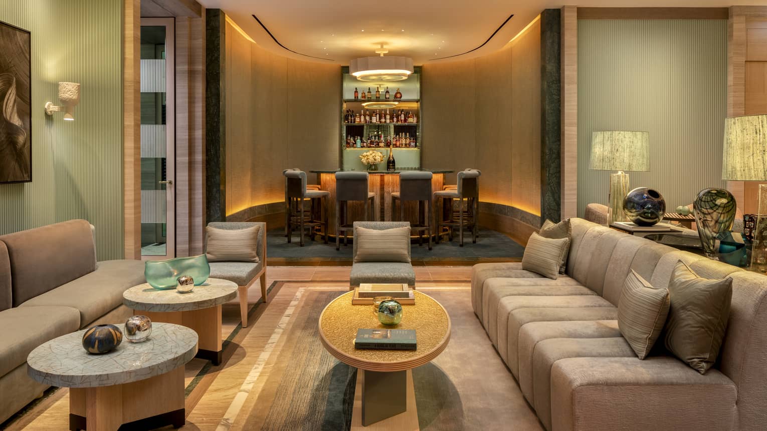 Restaurant?s private bar area, seen through lounge seating area with beige sofas and small coffee tables