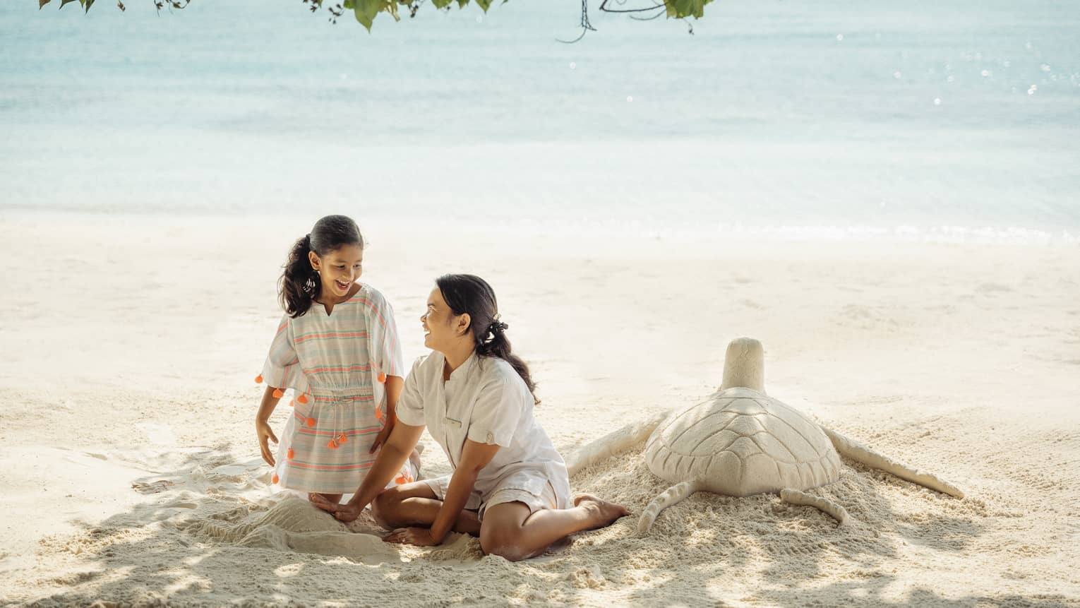 Two children building sandcastles on a beach
